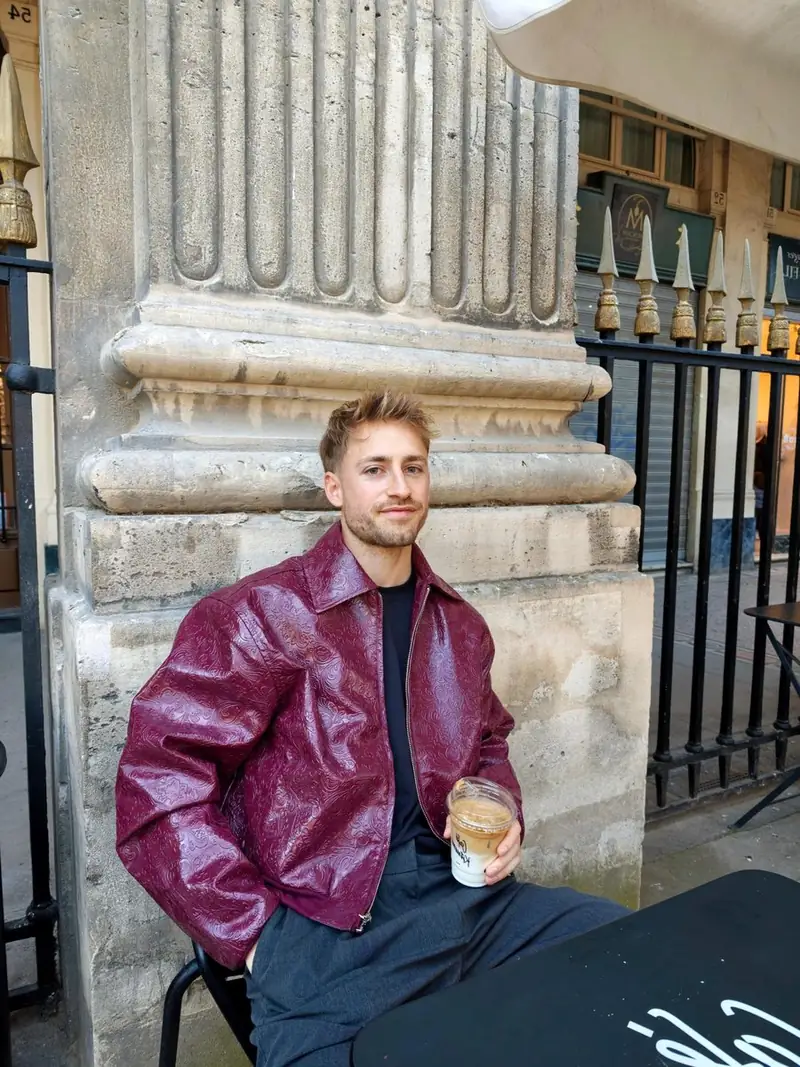 Hugo Plessis en pull blanc dans une rue parisienne